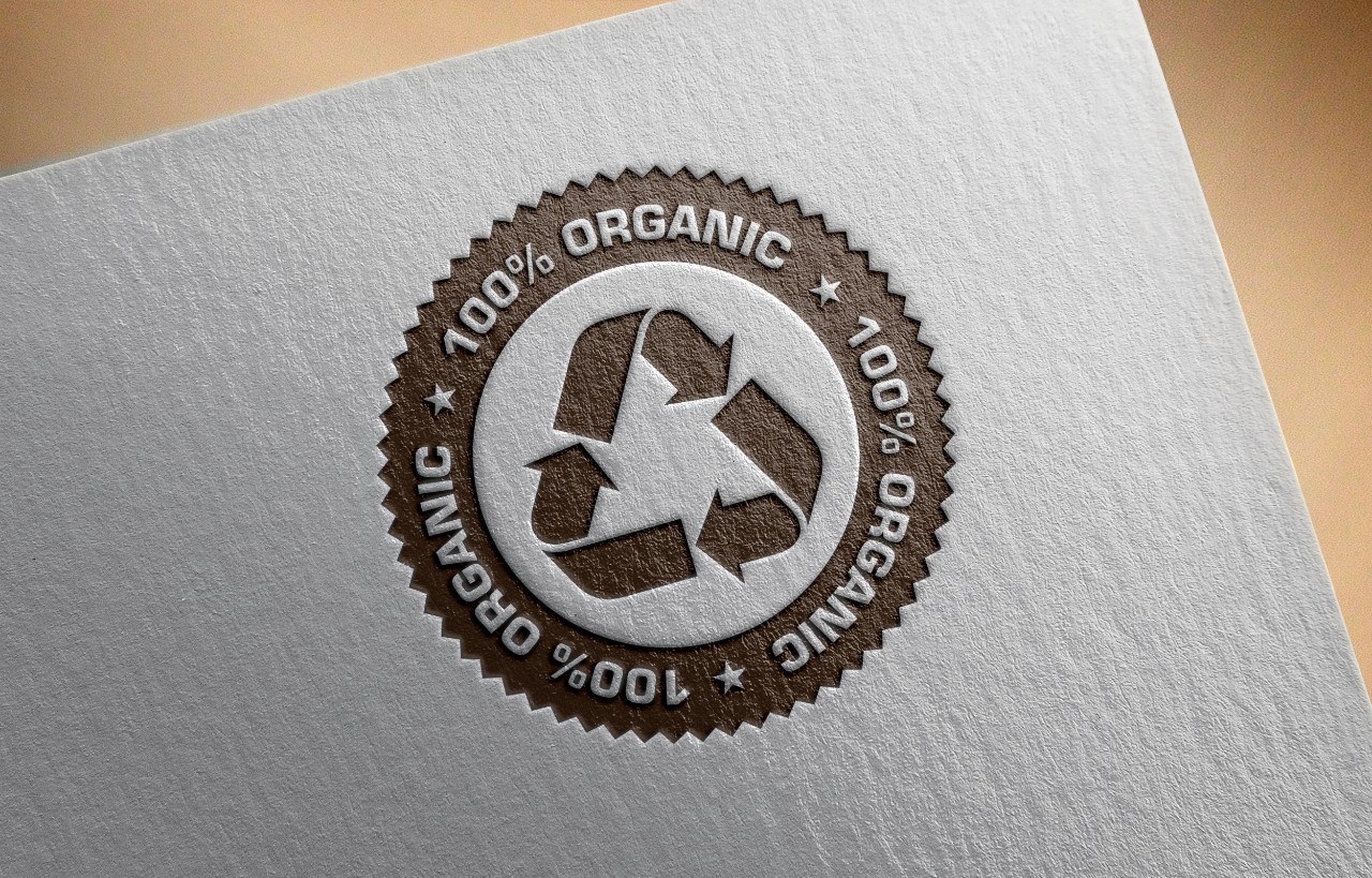 Recycle logo letterpressed and hot stamped on recycled paper background.